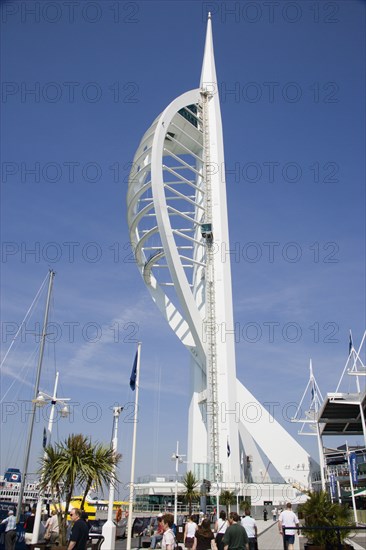 ENGLAND, Hampshire, Portsmouth, The Spinnaker Tower the tallest public viewing platforn in the UK at 170 metres on Gunwharf Quay with people walking along the waterfront area