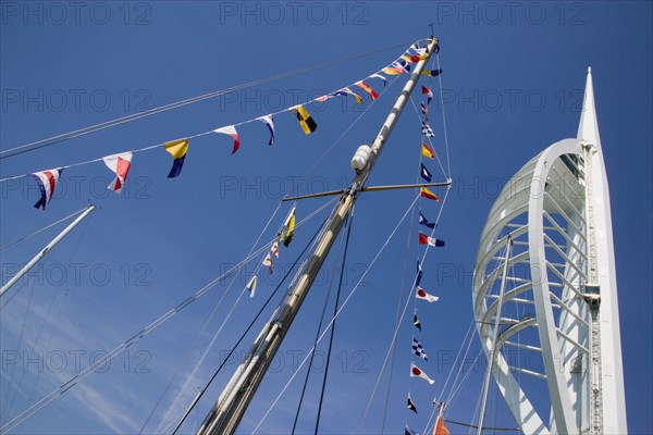 ENGLAND, Hampshire, Portsmouth, The Spinnaker Tower the tallest public viewing platforn in the UK at 170 metres on Gunwharf Quay with flags decorating a yachts rigging in the foreground