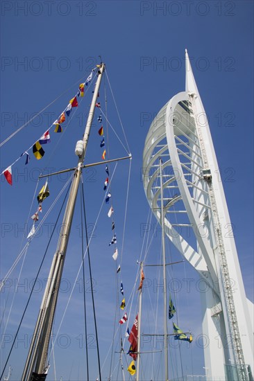 ENGLAND, Hampshire, Portsmouth, The Spinnaker Tower the tallest public viewing platforn in the UK at 170 metres on Gunwharf Quay with flags decorating a yachts rigging in the foreground