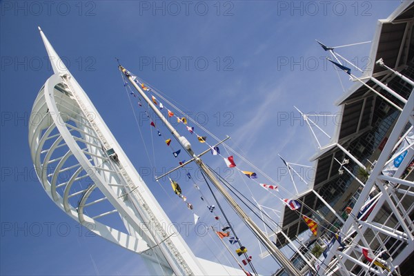 ENGLAND, Hampshire, Portsmouth, The Spinnaker Tower the tallest public viewing platforn in the UK at 170 metres on Gunwharf Quay with flags decorating a yachts rigging in the foreground
