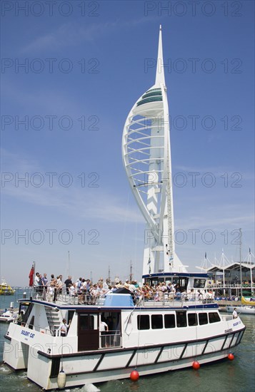 ENGLAND, Hampshire, Portsmouth, The Spinnaker Tower the tallest public viewing platforn in the UK at 170 metres on Gunwharf Quay with harbour tour boat entering the moorings