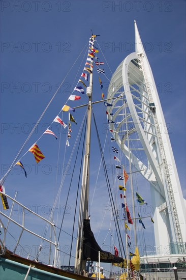 ENGLAND, Hampshire, Portsmouth, The Spinnaker Tower the tallest public viewing platforn in the UK at 170 metres on Gunwharf Quay with flag decorated yachts mast in the foreground