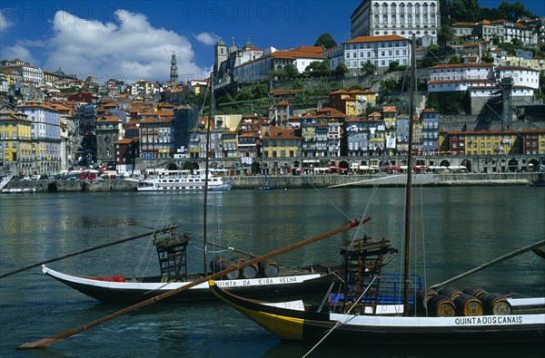 PORTUGAL, Porto, Oporto, The River Douro and waterside buildings with port barges or barcos rabelos moored in the foreground..