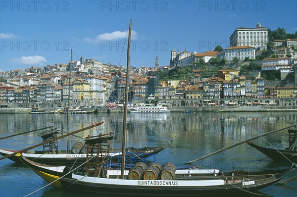 PORTUGAL, Porto, Oporto, The River Douro and waterside buildings with port barges or barcos rabelos moored in the foreground.