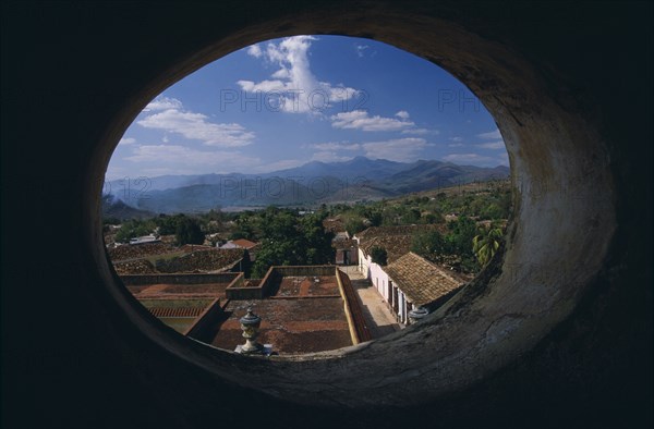 CUBA, Trinidad, View across red tiled city rooftops framed by oval window in Iglesia San Franciso de Paula.