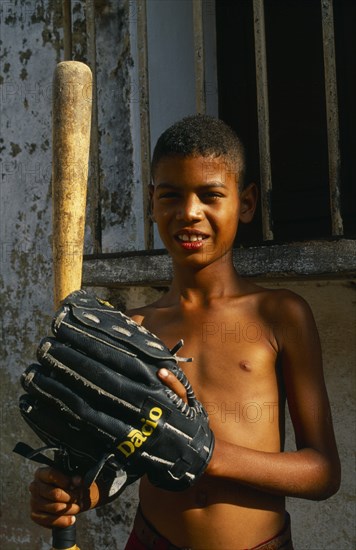 CUBA, Trinidad, Portrait of young Cuban boy with baseball bat and glove.