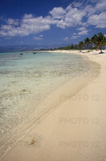 CUBA, Peninsula de Ancon, "Empty strip of sandy beach, clear shallow water and palms near Trinidad."