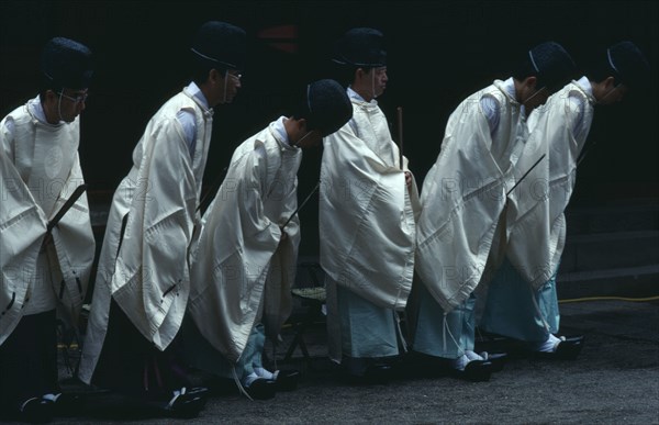 JAPAN, Honshu, Tochigi, Nikko.  Shinto priests watch and bow as the omikoshi or residence of the local kami or deity is carried past at Futara-gu Jinga during the Tosho-gu festival.