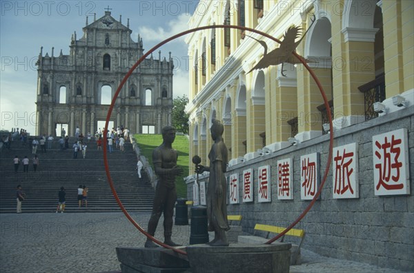MACAU, , St Pauls Ruins with sculpture of a man and woman holding a flower standing in a red ring.