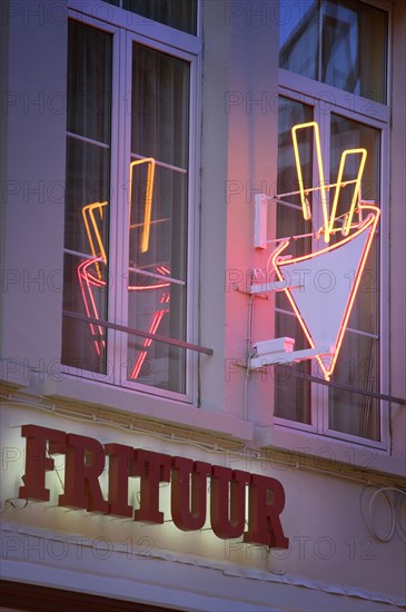 BELGIUM, Flemish Region, Antwerp, Detail of a neon chip shop sign with reflection in window.