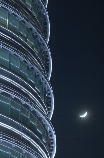 MALAYSIA, Peninsular, Kuala Lumpur, Detail of the Petronis Towers at night with a crescent moon behind.