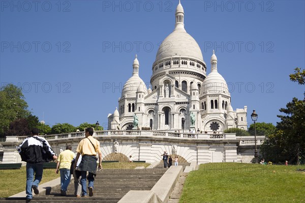 FRANCE, Ile de France, Paris, Montmartre Tourists on the steps leading up to the front of the chuch of Sacre Couer