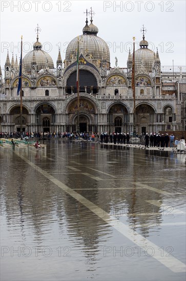 ITALY, Veneto, Venice, Aqua Alta High Water flooding in St Marks Square showing St Marks Basilica at the end of the flooded piazza