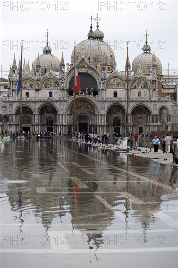 ITALY, Veneto, Venice, Aqua Alta High Water flooding in St Marks Square showing St Marks Basilica at the end of the flooded piazza