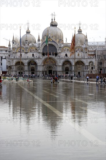 ITALY, Veneto, Venice, Aqua Alta High Water flooding in St Marks Square with St Marks Basilica at the far end of the flooded piazza