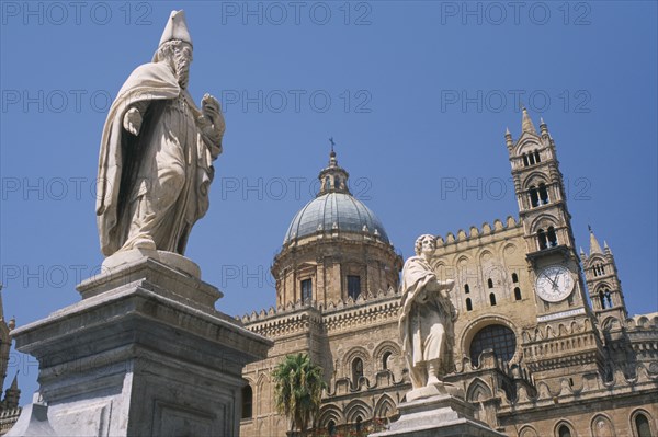 ITALY, Sicily, Palermo, II Duomo Cathedral exterior with religious statues and section of domed roof and clock behind