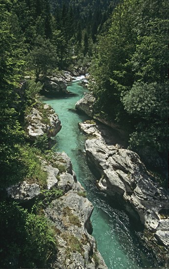 SLOVENIA , Trenta Valley, "The clear green water of the Soca River flowing through a narrow gorge below Felika Korita Soce a narrow wooden suspension bridge,the rocks have been shaped by the power of the water "