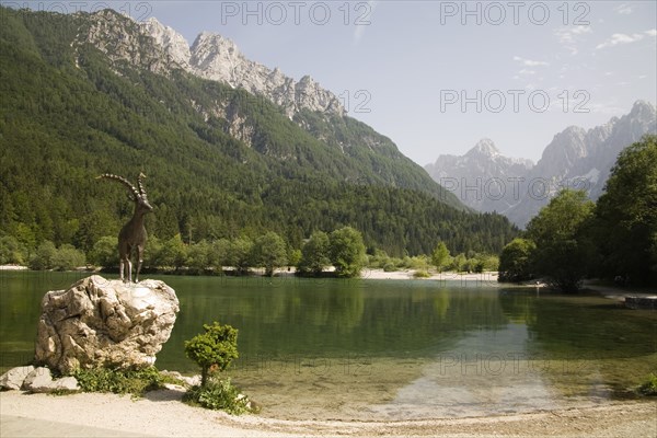 SLOVENIA , Kranjska Gora, Julian Alps, The famous Ibex statue at Lake Jasna just a ten minute walk form the centre of the town at the entrance to Velika Pisnica near the road to Vrsic Mountain Pass with Mounts Razor and Prisank in the background