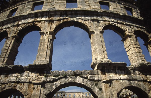 CROATIA, Istria, Pula, "Arches of Roman Arena, built towards the end of the 1st century BC. Capable of seating 22,000 Roman spectators, it is the sixth largest amphitheatre in the world. Today it retains its original purpose as a venue for entertainments, housing a series of summer concerts every year."