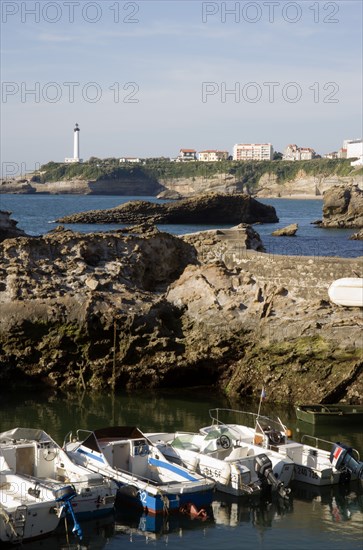 FRANCE, Aquitaine Pyrenees Atlantique, Biarritz, The Basque seaside resort on the Atlantic coast. Boats in the safe harbour of the Port des Pecheurs with the lighthouse in the distance.