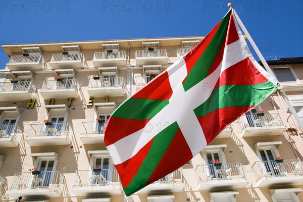 FRANCE, Aquitaine Pyrenees Atlantique, Biarritz, The Basque seaside resort on the Atlantic coast. Basque flag flying in front of hotel balconies