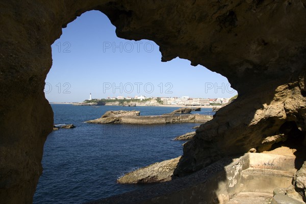 FRANCE, Aquitaine Pyrenees Atlantique, Biarritz, The Basque seaside resort on the Atlantic coast. The town and lighthouse seen through a rocky arch.