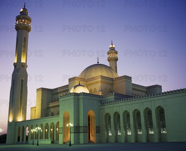 BAHRAIN, Manama, Al Faith Mosque. Exterior and minaret illuminated at night.