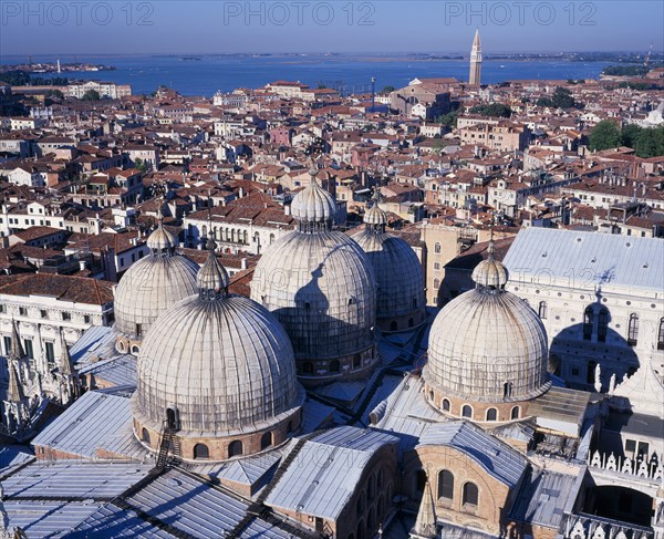 ITALY, Veneto, Venice, View from the Campanile over domed rooftops of St Mark’s Basilica and city beyond.