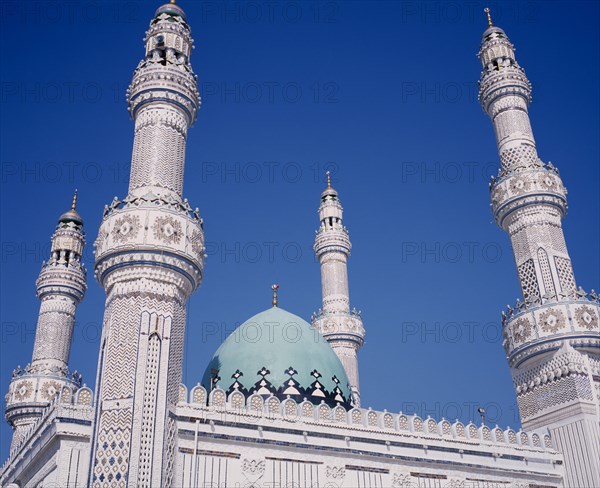 KUWAIT, Kuwait City, Iranian Mosque. Part view of highly decorated facade of mosque showing domed roof and four minarets.