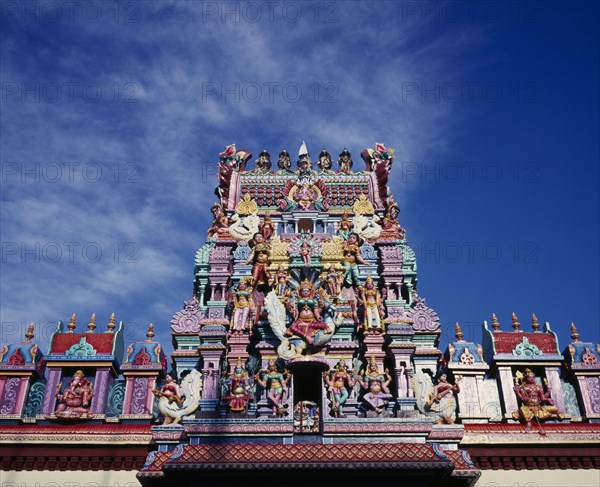 MALAYSIA, Penang, Georgetown, Sri Mariamman Temple.  Part view of exterior roof and gopuram painted tower decorated with brightly painted figures of Hindu gods and characters.