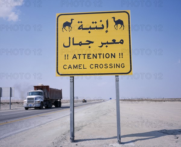 SAUDI ARABIA, Transport, Camel Crossing road sign on Eastern Highway to Dammam with passing truck behind.