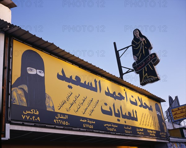 BAHRAIN, Muharraq Island, Markets, Shopfront sign with images of a woman in a veil and a woman in a Burqa.