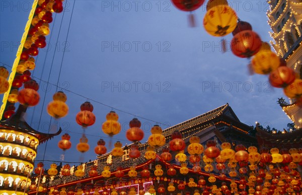 MALAYSIA, Penang, Kek Lok Si Temple, Temple roof decorated with lights and hung with red and yellow Chinese lanterns at Chinese New Year.