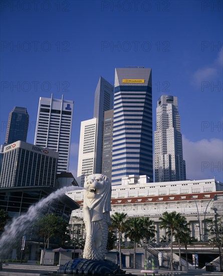SINGAPORE, Raffles Place, Merlion fountain in front of The Fullerton Hotel with highrise banks and office buildings behind.