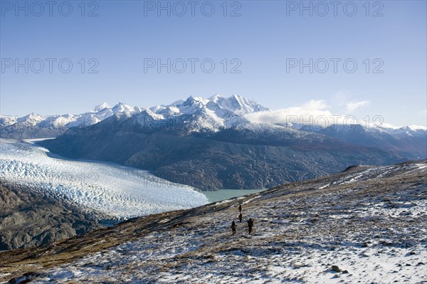 CHILE, Southern Patagonia, O'Higgins region , "Trekers walking in O'Higgins region of Patagonia, with O'Higgins Glacier in the background. Trek from Glacier Chico (Chile) to El Chalten (Argentina) "