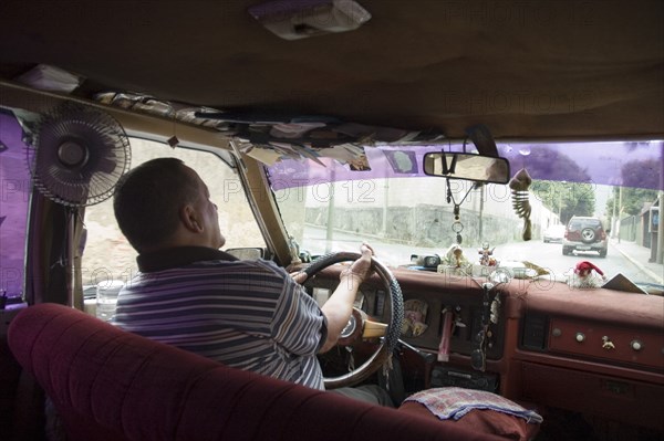 VENEZUELA, Caracas , Passenger seat view of a Caracas taxi including ventilation fan and dash-board ornaments