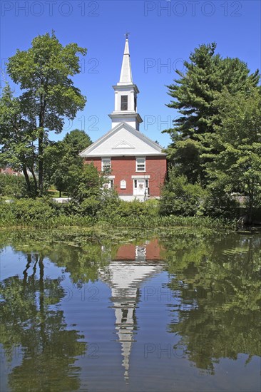 USA, New Hampshire, Harrisville, Community church refelected in pond.
