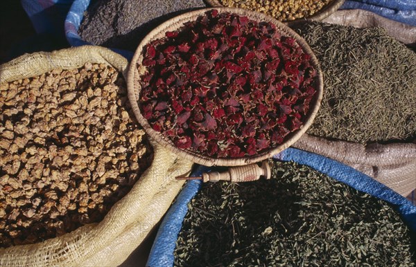 MOROCCO, Marrakech, Baskets of dried flower heads and leaves for sale at market.