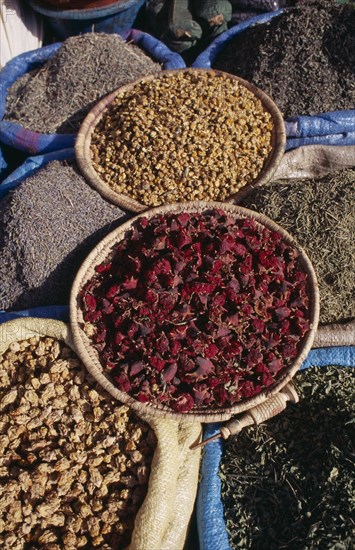 MOROCCO, Marrakech, Baskets of dried flower heads and leaves for sale at market.