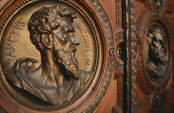 HUNGARY, Budapest, Basilica of St Stephen.  Detail of door with bronze relief carvings of the heads of the twelve apostles. Eastern Europe