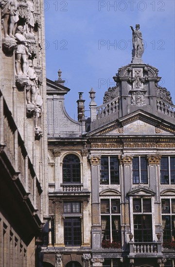 BELGIUM, Brabant, Brussels, Part view of facades of guild houses in Grand Place with gable rooftops and carved stone statues.