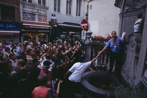 BELGIUM, Brabant, Brussels, Crowds surrounding the Manneken-Pis statue set up to produce beer.