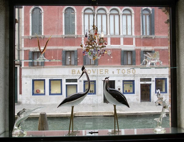 ITALY, Veneto, Venice, Glass display of birds and other objects in a window on Fondamente dei Vetrai beside the canal on the glassmaking island of Murano