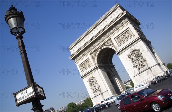 FRANCE, Ile de France, Paris, Traffic around the Arc de Triomphe in Place Charles de Gaulle with a street sign on a lamp post