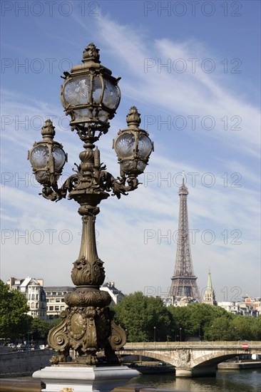 FRANCE, Ile de France, Paris, Art Nouveau lamp-post on Ponte Alexandre III bridge across the River Seine named after Tsar Alexander III of Russia with the Eiffel Tower in the distance