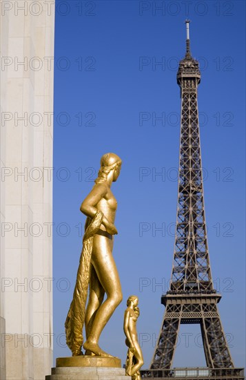 FRANCE, Ile de France, Paris, Gilded statues in the central square of the Palais de Chaillot with the Eiffel Tower beyond