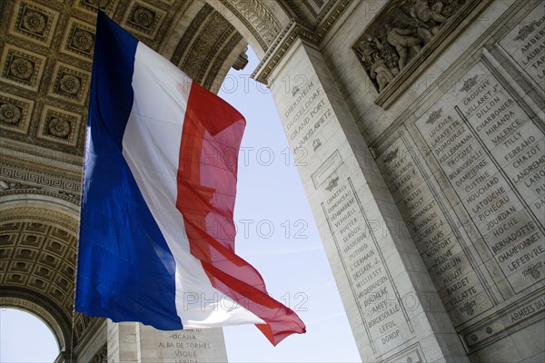 FRANCE, Ile de France, Paris, The French Triclour flag flying beneath the central arch of the Arc de Triomphe