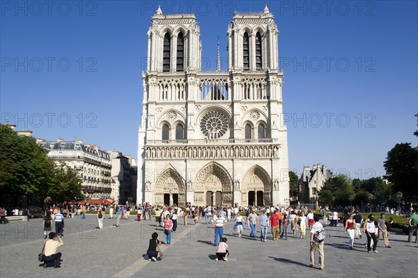 FRANCE, Ile de France, Paris, Tourists in the suare at the west front of the Gothic style Notre Dame Cathedral on Ile de la Cite
