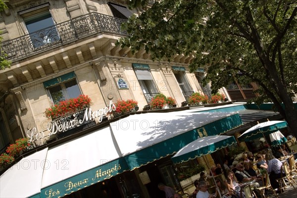 FRANCE, Ile de France, Paris, People at pavement tables outside Les Deux Magots the famous literary cafe frequented by the Surrealists on Place St Germain des Pres