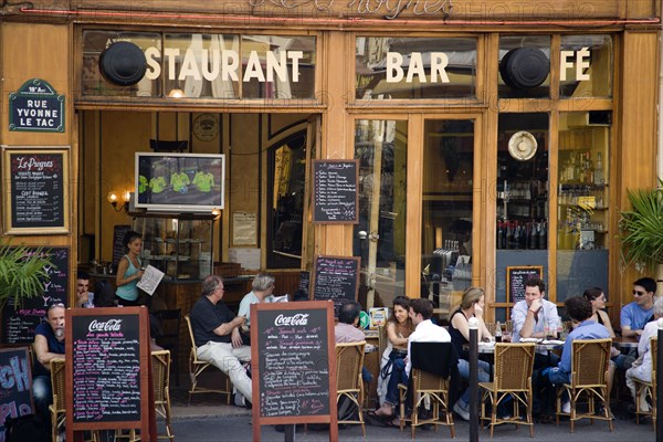 FRANCE, Ile de France, Paris, Montmartre People sitting at pavement tables outside a cafe on Rue Yvonne le Tac